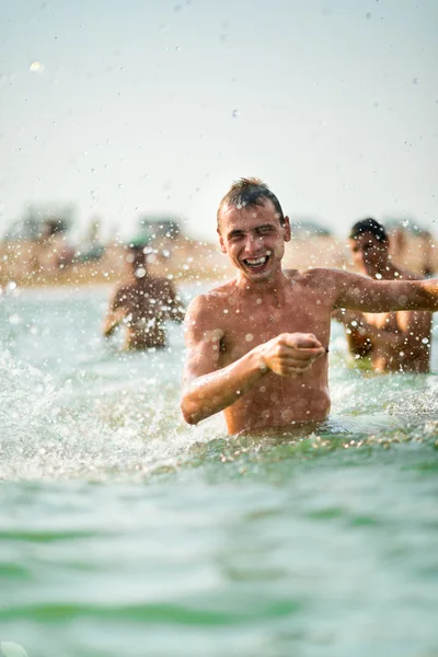 Uomo allegro che fa una spruzzata d'acqua — Foto Stock