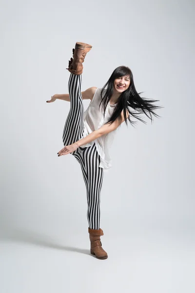 Girl in boots throws leg smiling — Stock Photo, Image