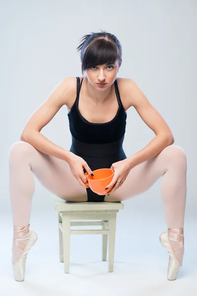 Gimnasta agresiva sentada en una silla con taza — Foto de Stock