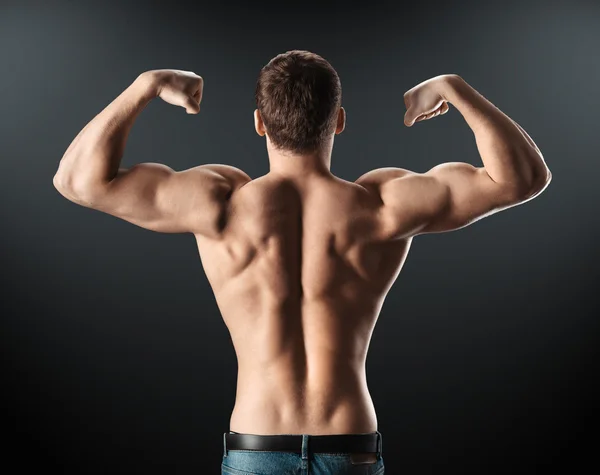 Culturista mostrando músculos espalda y brazos — Foto de Stock