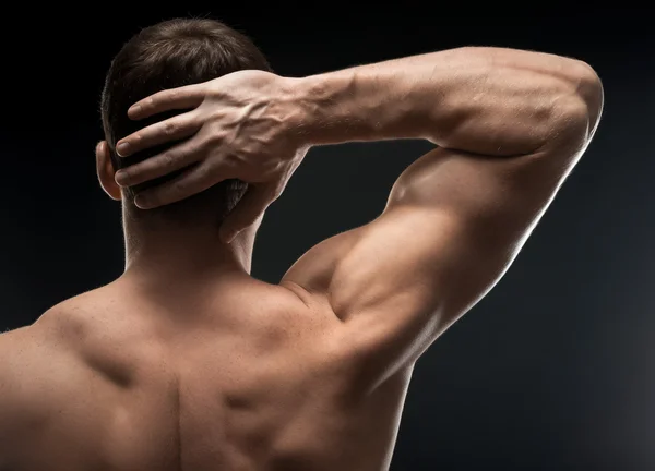 Bodybuilder hand in het donker — Stockfoto