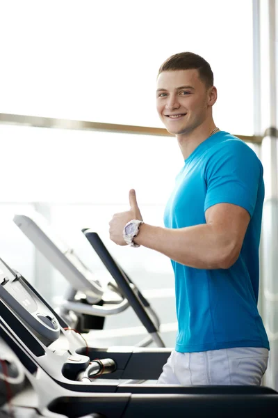 Man showing thumbs up near the treadmill — Stock Photo, Image