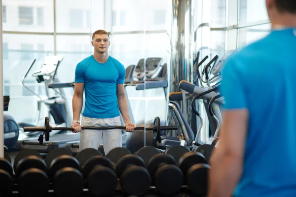 Man doet oefeningen met lange halter — Stockfoto