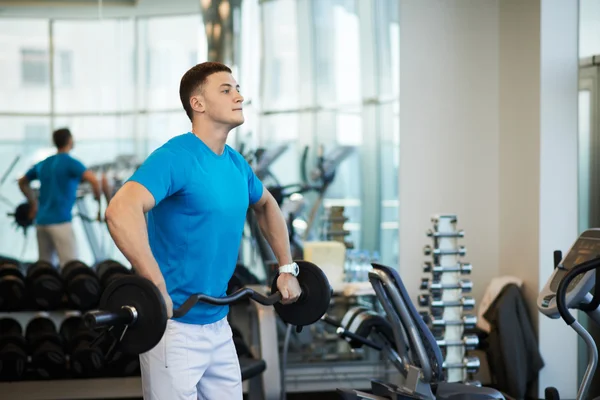 Man doet oefeningen met lange halter — Stockfoto