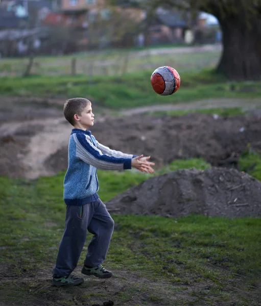 Chłopiec w okolicy odgrywa piłkę — Zdjęcie stockowe