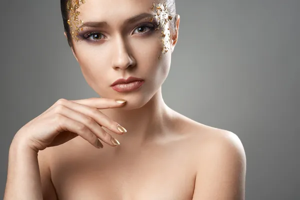 Chica bonita con el arte de maquillaje de oro — Foto de Stock