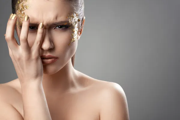 Hübsches Mädchen mit goldener Make-up-Kunst — Stockfoto