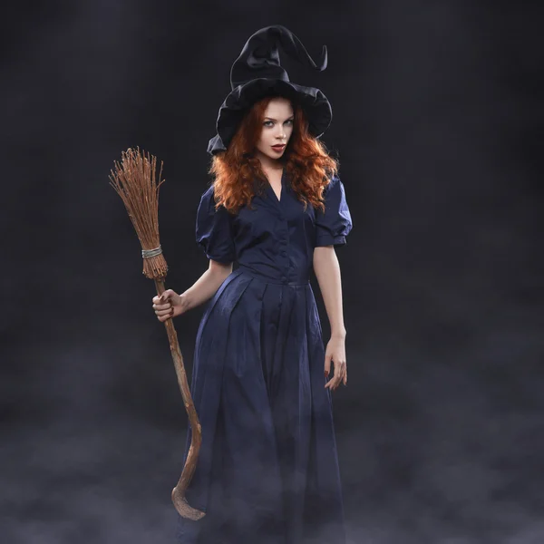 Young beautiful red-haired witch in the dark fog — Stockfoto