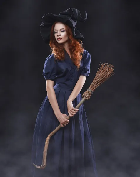 Young beautiful red-haired witch in the dark fog — Stockfoto