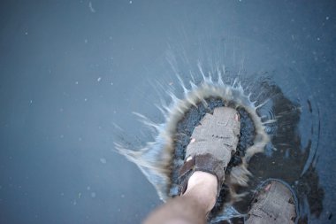 sandalet yağmur suyu birikintisi içinde sıçramasına