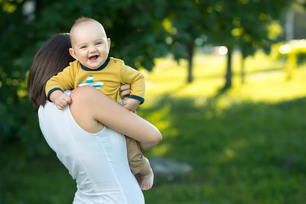 Glad mamma håller en ung son — Stock fotografie