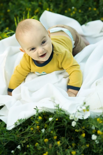 Copil mic întins pe un scutec iarba — Fotografie, imagine de stoc
