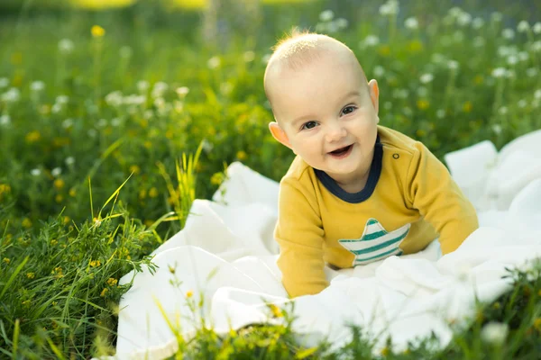 Little child lying on a diaper the grass — Stock Photo, Image