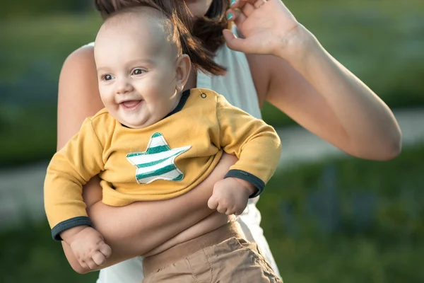 Mãe feliz segurando um filho jovem — Fotografia de Stock