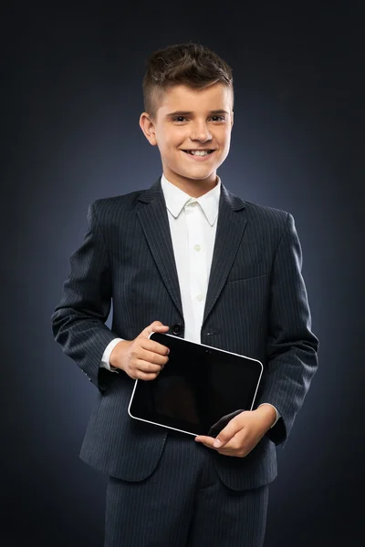Junge im schwarzen Anzug hält Tablet in der Hand — Stockfoto