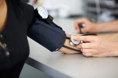 Doktor hastanın kan basıncını ölçer