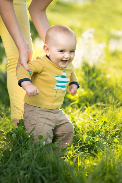 Mãe ensina filho andando grama — Fotografia de Stock