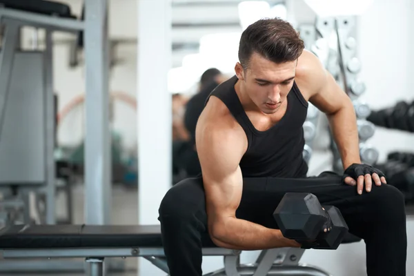 Hombre haciendo ejercicios mancuerna bíceps músculos — Foto de Stock