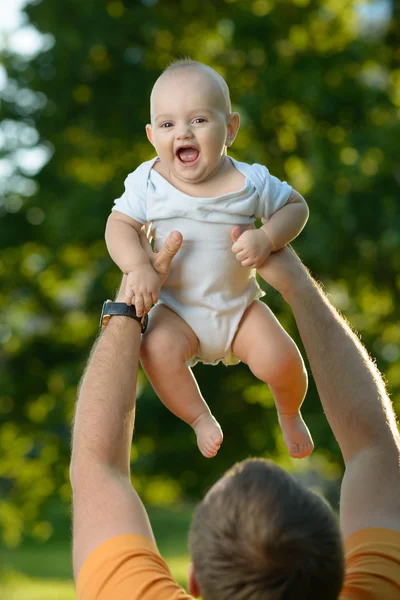 Dad throws up his son playing Stock Photo