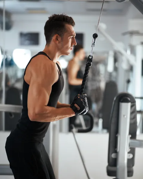 Homem exercitando-se em treinador para músculos tríceps — Fotografia de Stock