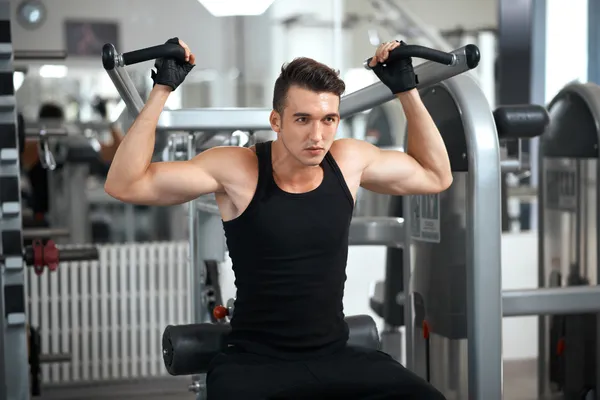 Man exercising in trainer for dorsi muscles — Stock Photo, Image