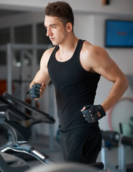 Athlete exercising on a stationary bike — Stock Photo, Image