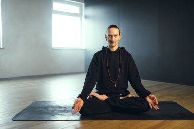 Yogi adam Padmasana 'da Gyan Mudra ile oturuyor. Stüdyoda yoga çalışması..
