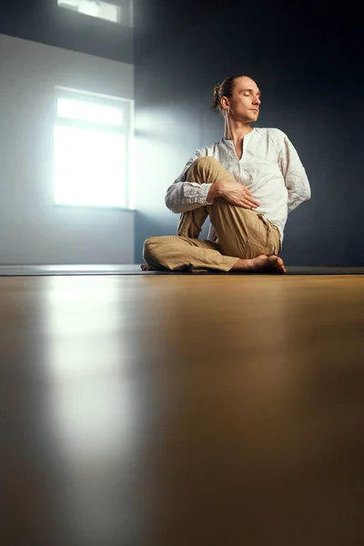 The yogi man do ardha matsyendrasana. Yoga practice in the studio. — Stock Photo, Image