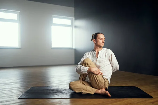 Йог делает ardha matsyendrasana. Практика йоги в студии. — стоковое фото
