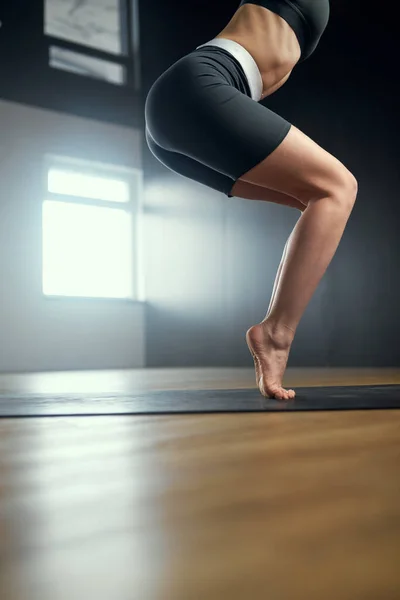 Prática de ioga no estúdio. A mulher de pé em seus dedos dos pés. — Fotografia de Stock