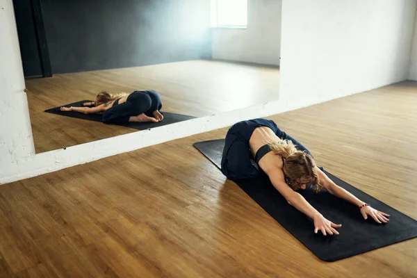 A mulher yogi faz pose de criança. Prática de ioga no estúdio. — Fotografia de Stock
