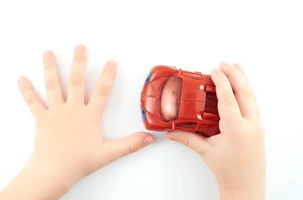 Child.Children 's manos con un coche de juguete sobre un fondo blanco — Foto de Stock