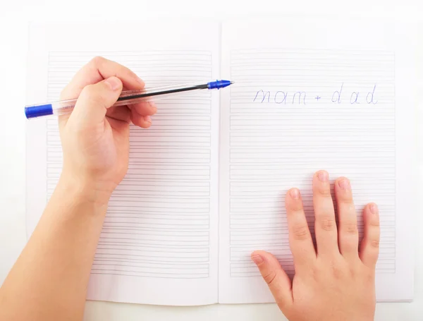 Children.A 小さな子供の手がボールペンでノートの言葉で書く ストック画像