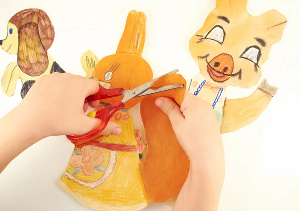 Çocuk elinde makasla kağıt rakamlar kesmek