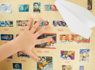 Child's hand on a background stamp collection on the theme of the cosmos clipart