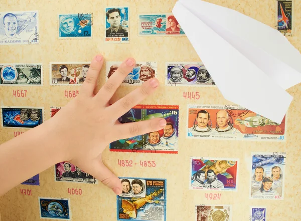 Child's hand on a background stamp collection on the theme of the cosmos — Stock Photo, Image