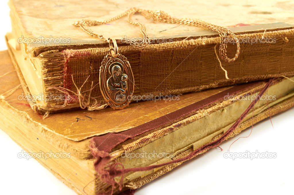 Ancient books.Gold chain with pendant of the Virgin on a background of old battered books