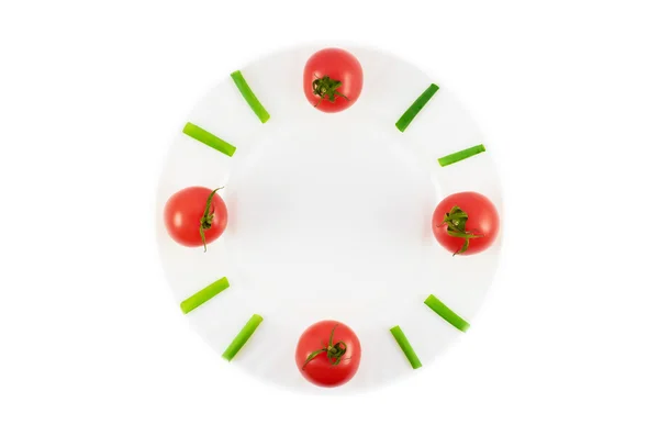 Horloge naturelle.Assiette avec tomates et oignons verts dans une horloge naturelle — Photo