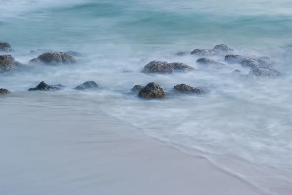 海の水を持っていた石を吹く — ストック写真