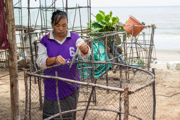 Las mujeres pescadoras tejen una trampa para peces. —  Fotos de Stock