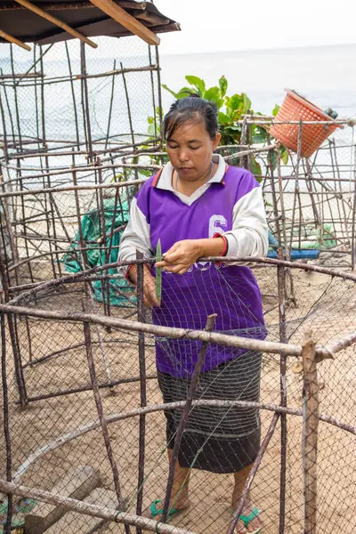 Woman fishermen is weaving fish-trap — Stock Photo, Image