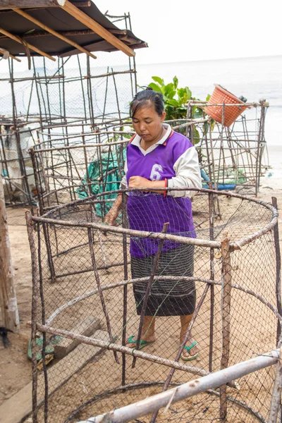 Las mujeres pescadoras tejen una trampa para peces. —  Fotos de Stock