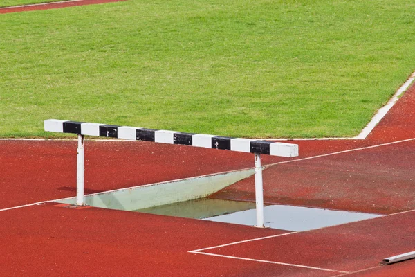 Hürden auf der roten Laufstrecke für den Wettkampf vorbereitet. — Stockfoto