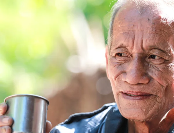 Старый веселый старик держит чашку кофе — стоковое фото