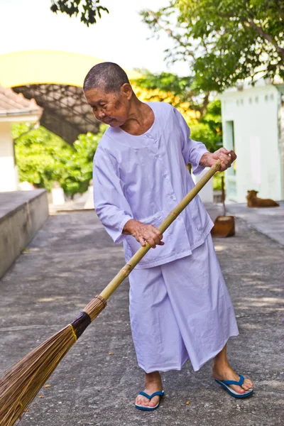 Cholburi june 23 : buddha nun sweeping autumn leaves — Stock Photo, Image