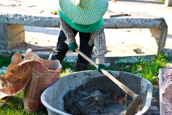 Trabalhador da construção civil misturando concreto na fundação com um sho — Fotografia de Stock