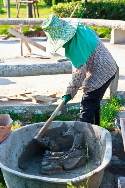 Trabajador de la construcción mezclando hormigón en la fundación con un sho —  Fotos de Stock