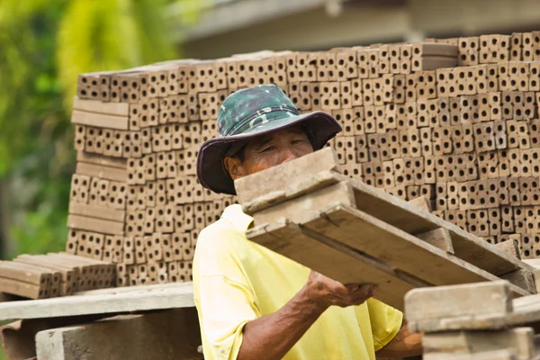 Uomo operaio solleva il legno di produzione di mattoni in Thailandia — Foto Stock