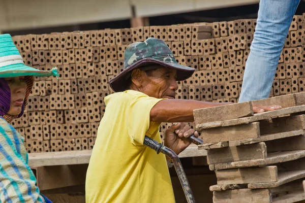 Mannen arbetare lyfter trät av produktionen av tegelstenar i thailand — Stockfoto