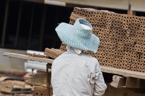 Femme ouvrière disloque une brique de production de briques dans — Photo